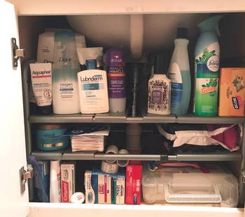 reviewer's under-sink cabinet organized with expandable shelf kit