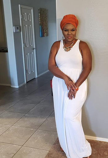 a reviewer wearing an orange head scarf and the maxi dress in white 