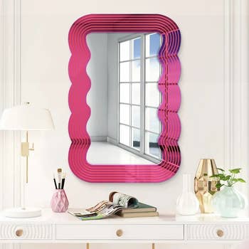 the pink mirror hung vertically on a wall