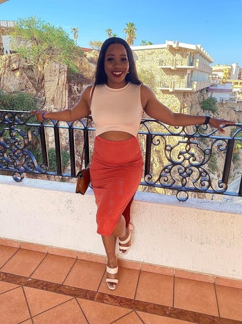 reviewer wearing the same dress with a white and orange design