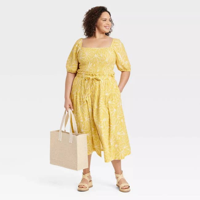 model wearing yellow midi skirt with white floral pattern on it