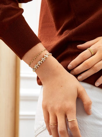 a model wearing a gold pisa bracelet with the name 