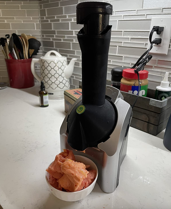 reviewer photo of the soft serve maker next to a bowl of soft serve