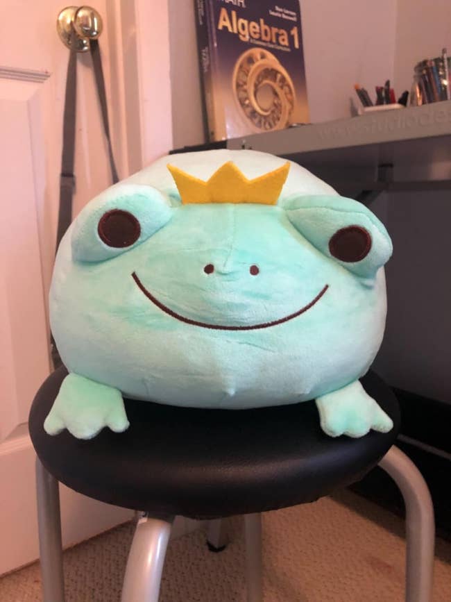 a big squishy frog stuffed animal with a tiny crown on its head