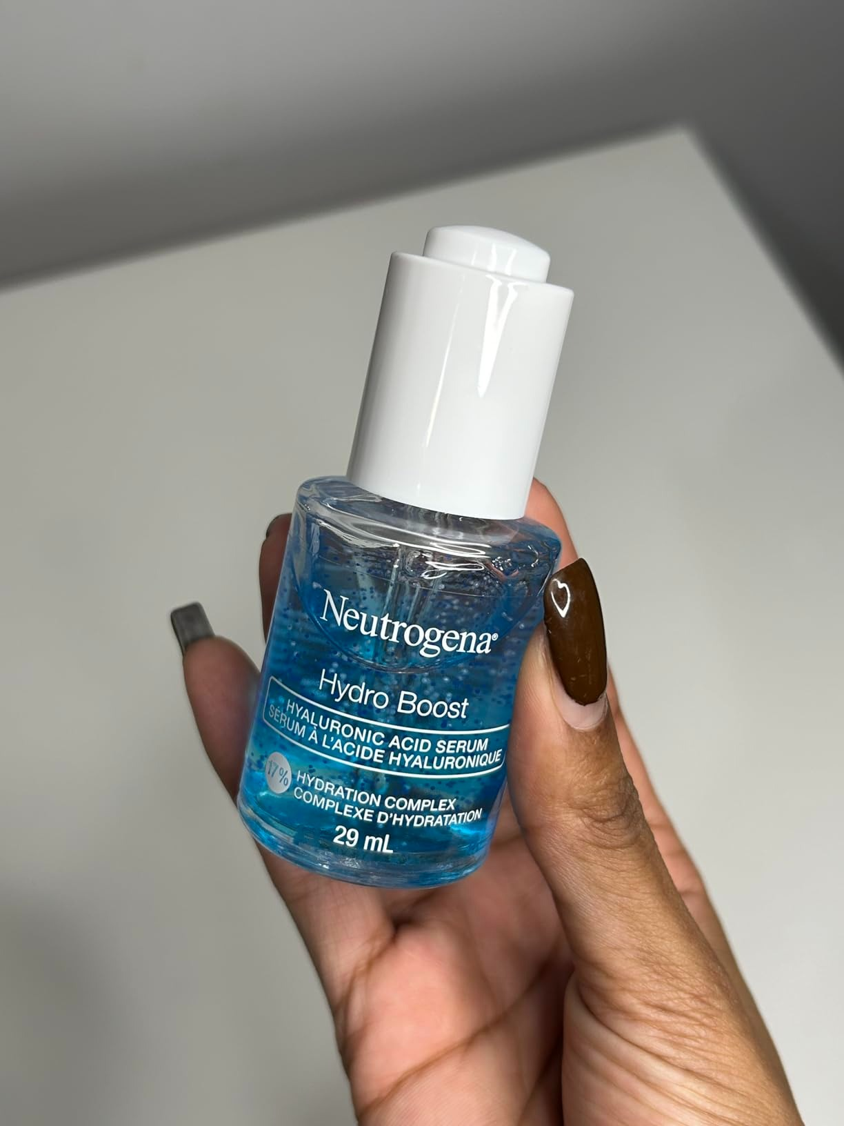 A manus  holds a 29 ml vessel  of Neutrogena Hydro Boost Hyaluronic Acid Serum