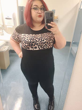 reviewer wearing the top in black with leopard print across the chest and sleeves 