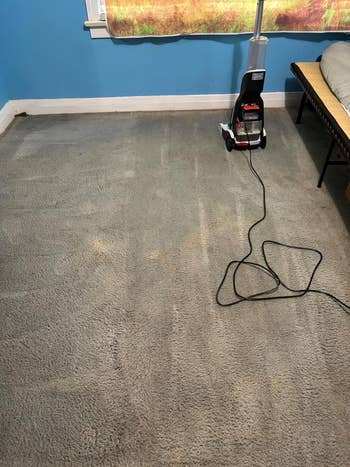 Same country   aft  cleaning with nary  disposable   stains and a vacuum cleaner positioned adjacent   the bed