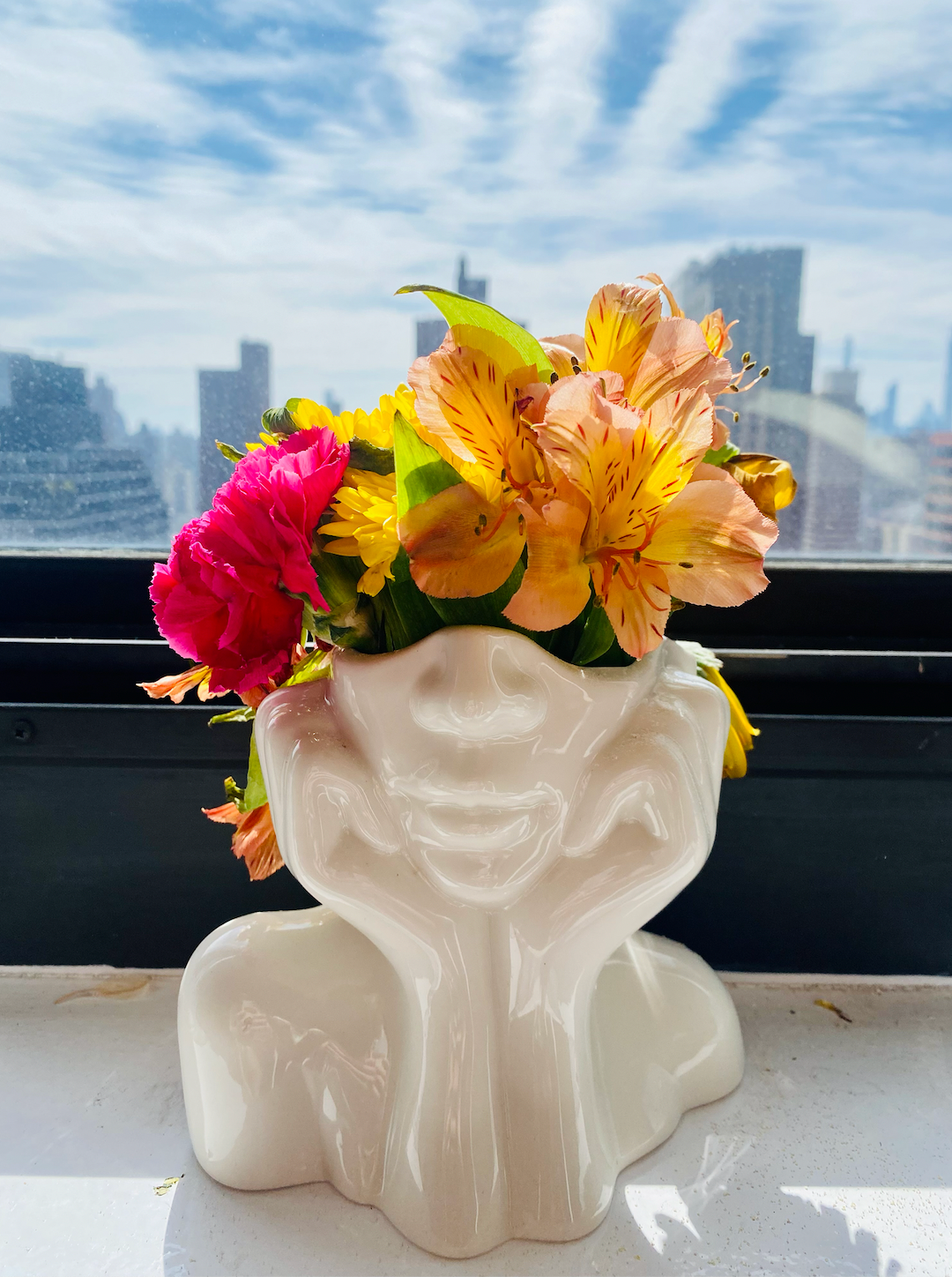 A white vase depicting the bottom half of a face with its head in its hands 