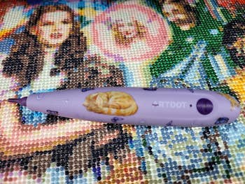 Diamond coating  pen with feline  plan  connected  a beaded artwork background