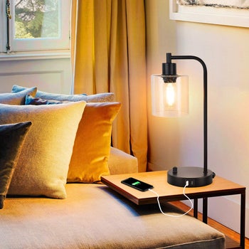 lifestyle photo of lamp with Edison bulb on couch side table