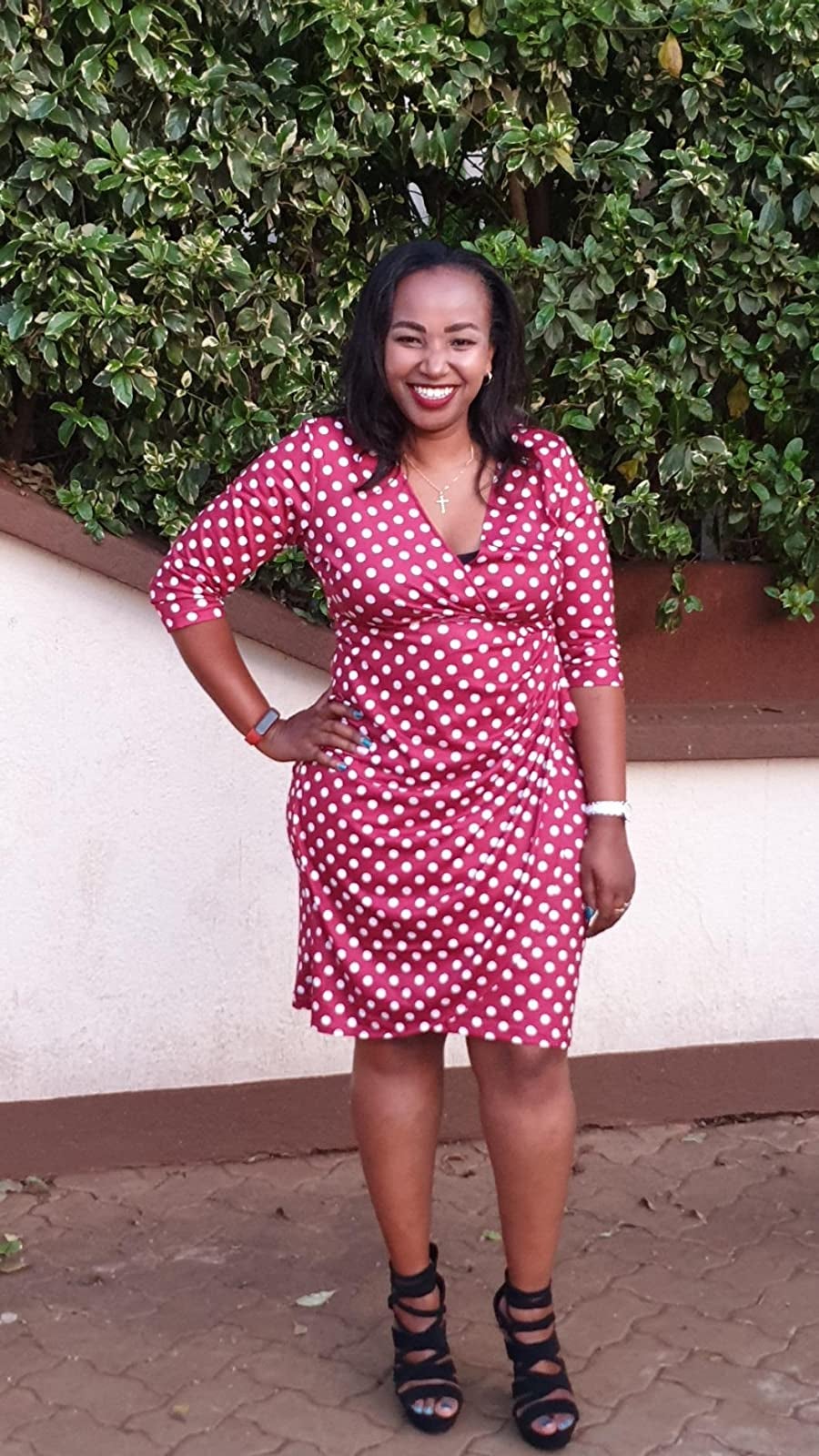 Reviewer is wearing the red short wrap dress with white polka dots throughout