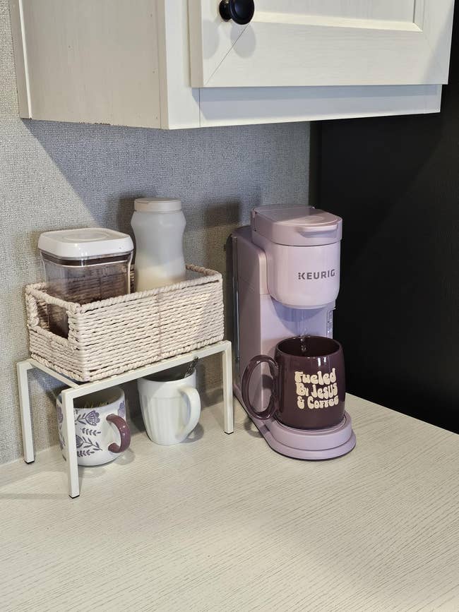 Coffee nook with a Keurig machine, mugs, sweetener and creamer acceptable connected a countertop, including a mug labeled
