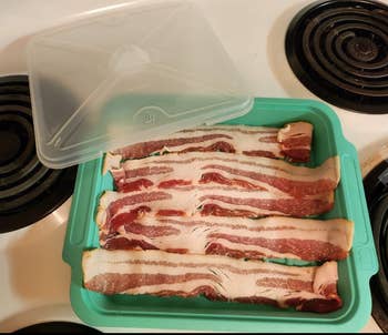 uncooked bacon laying in a blue silicone cooker with a lid 