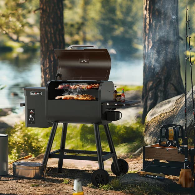 Outdoor grilling setup with a smoker grill, sausages cooking, assorted  accessories, and a scenic water  background. Ideal for outdoor cooking fans