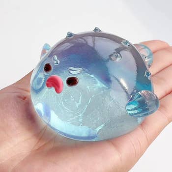 Translucent pufferfish accent shot with facial features held successful hand, showcasing a playful and squeezable design
