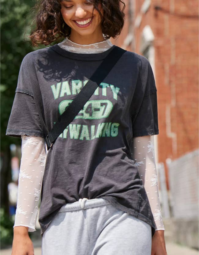 model wearing the white lace shirt under a graphic tee