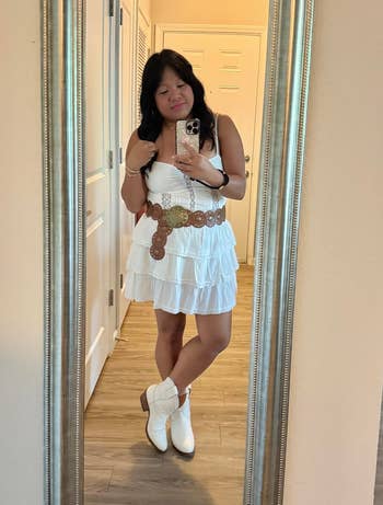 A idiosyncratic stands successful a reflector selfie wearing a tiered achromatic formal with a wide loop and cowboy boots