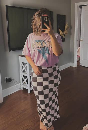 reviewer wearing a pink tee over the black and white checkered dress