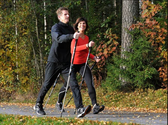 Two models walking while holding two thin metal walking sticks 