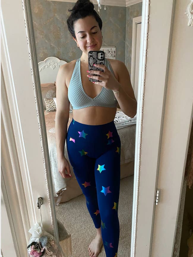 BuzzFeed writer Fabiana Buontempo wearing blue sports bra with navy blue rainbow star-print workout leggings