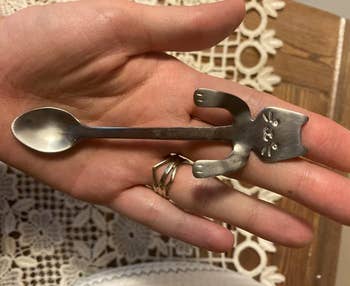 reviewer holding tiny spoon that fits in the palm of their hand