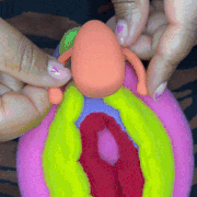 Demonstration of placing vibrator on colorful vulva model