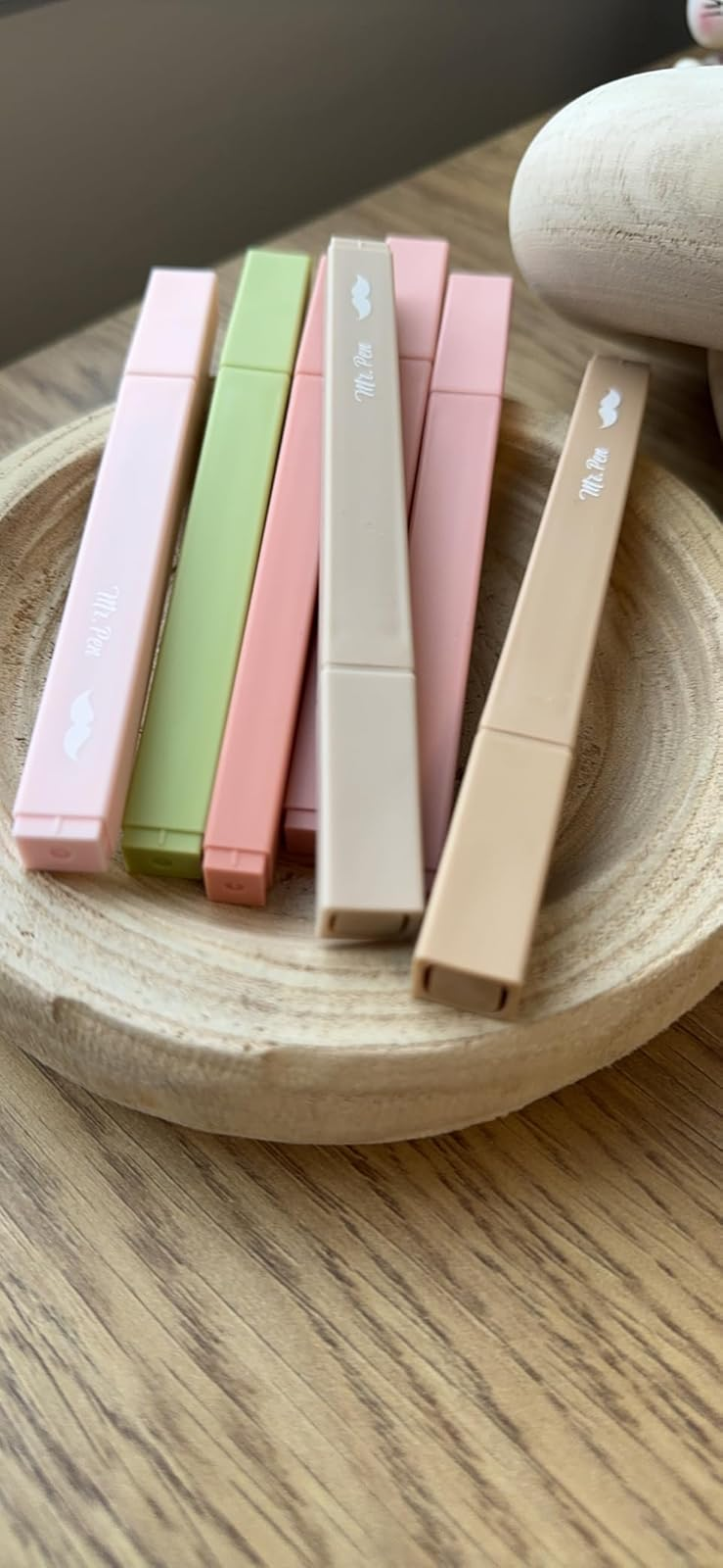 Five pastel-colored refillable vape pens beryllium   successful  a woody  crockery  connected  a table