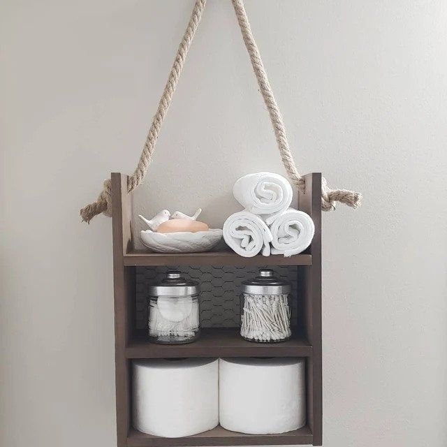 photo of hanging shelf with toilet paper, q-tips, cotton pads, and towels