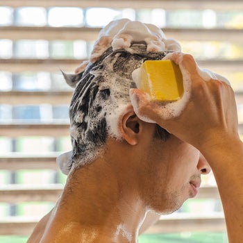 a model using the bar to apply shampoo to hair