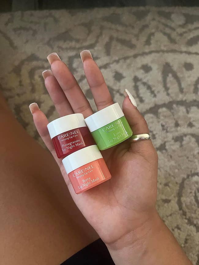 A reviewer holding the three types of lip masks