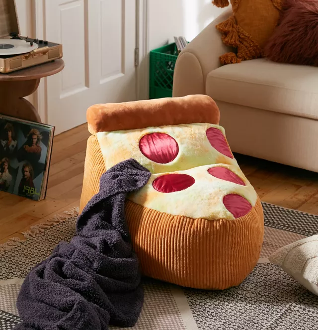 a bean bag chair that looks like a slice of pizza with a black throw blanket falling off of it