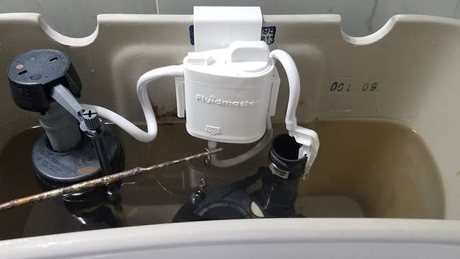 a reviewer's cleaning cartridge system in their toilet tank
