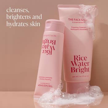 two pink bottles of the facial cleanser surrounded by bubbles