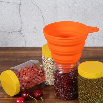 the orange silicone funnel in a jar of beans
