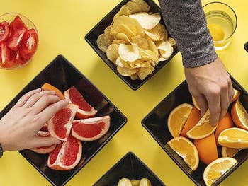hands grabbing fruit from different plates