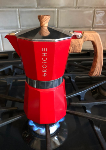 the red moka pot heating up on a stove
