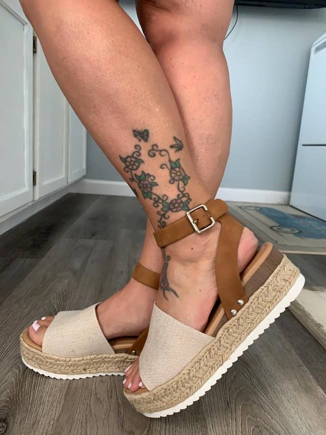 Tattooed limb  wearing level    sandals with a woven sole and ankle strap, shown successful  a location  setting