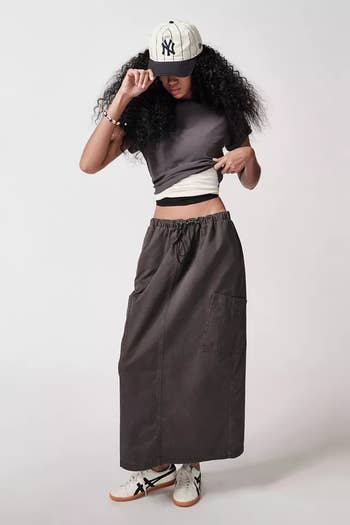 Model posing in a grey skirt