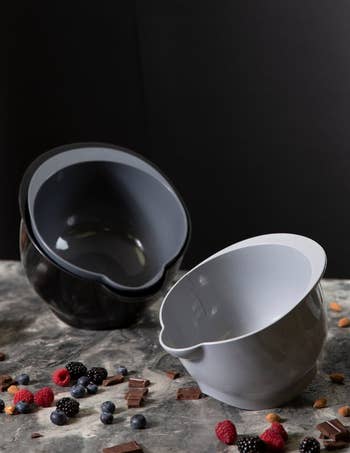 The grey stacking bowl tilted showing the internal measure and the black and dark grey stacked and tilted
