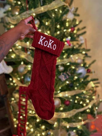 A reviewer holding a red stocking with the name Koko on it