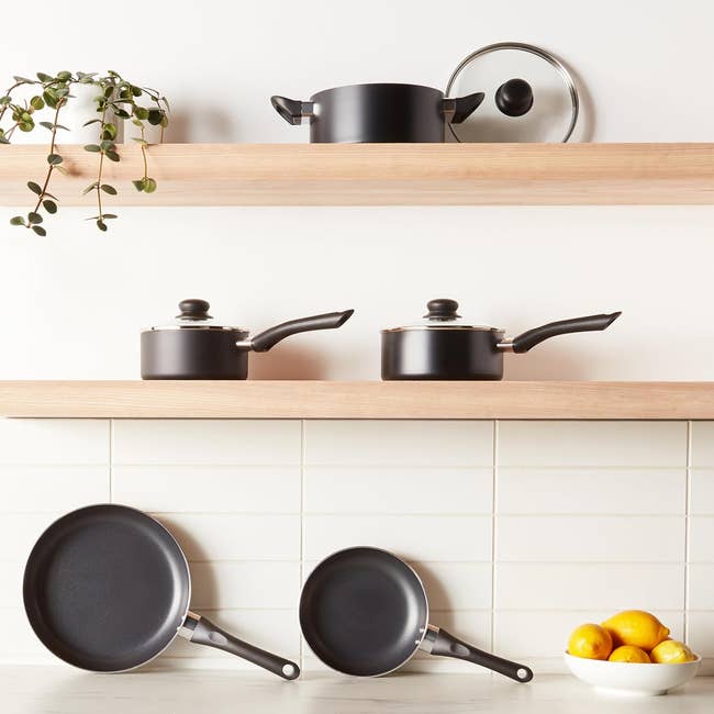 pots, pans, lid, and a vessel of lemons. Modern room mounting with a works for decor