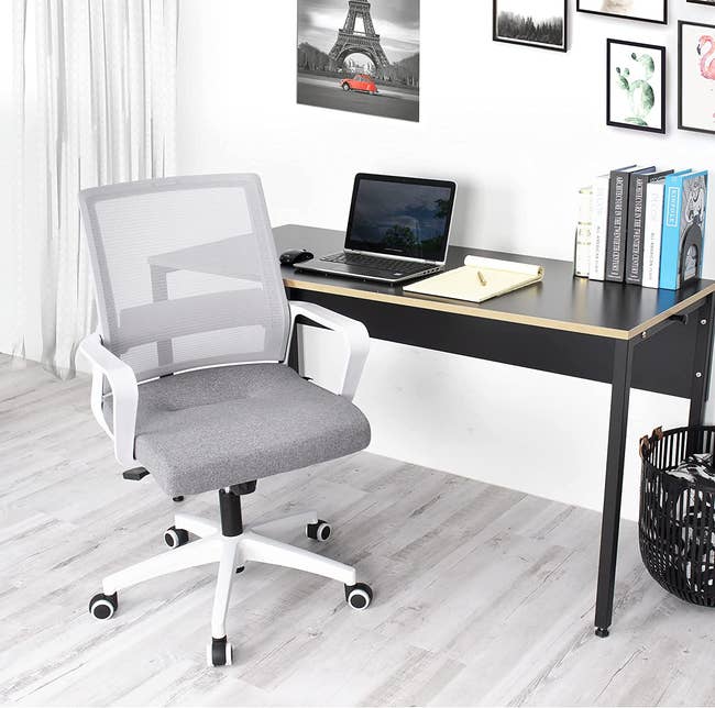 the gray and white chair sitting beside a white desk