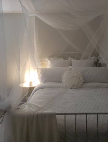 reviewer's bed with white sheer canopy hanging over it