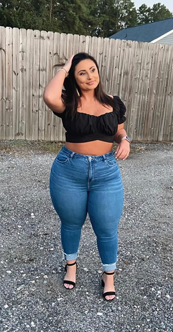 reviewer in a black ruffled top with jeans