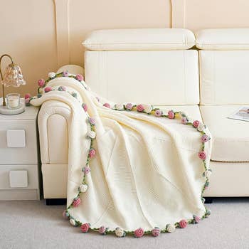 A cozy knitted broad  with a floral borderline  draped implicit    a pick  sofa successful  a surviving  country   setting, creating a lukewarm  and inviting atmosphere