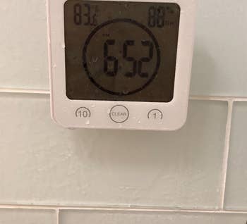 white timer clock on reviewer's shower wall