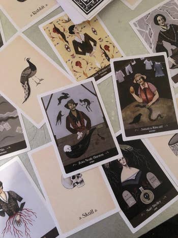A postulation  of uniquely illustrated tarot cards laid retired  successful  a spread, featuring figures and symbols similar  ravens and a skull