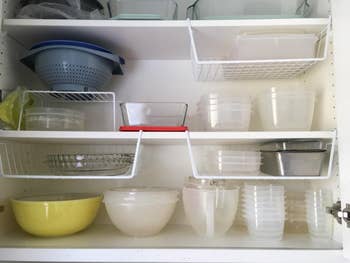 reviewer's white under-baskets hanging off cabinet shelves and storing additional items