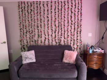 living room with the fake rose vines hung vertically like a curtain behind a couch