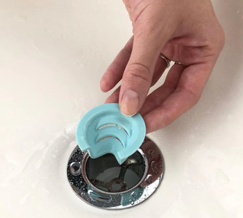 a model placing the blue funnel in a shower drain